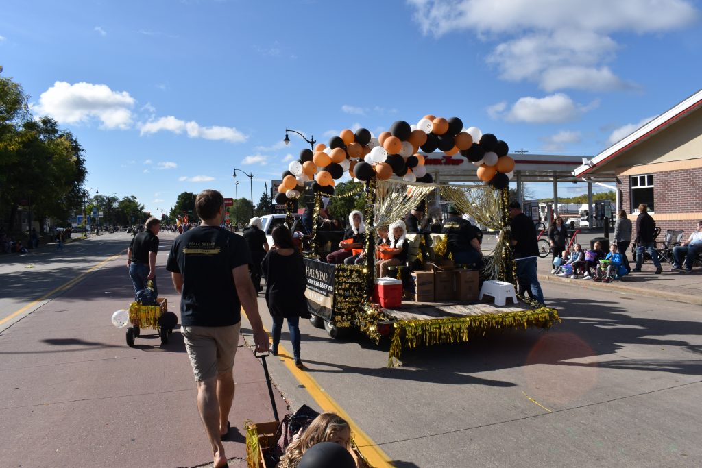 People walking alongside parade float.