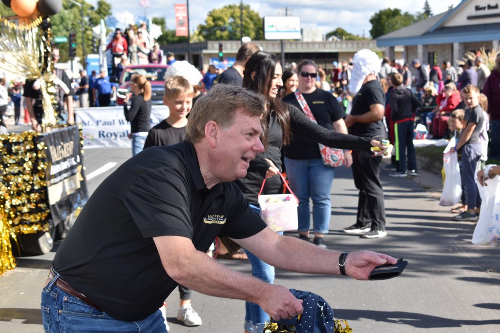 Man handing out items in parade.