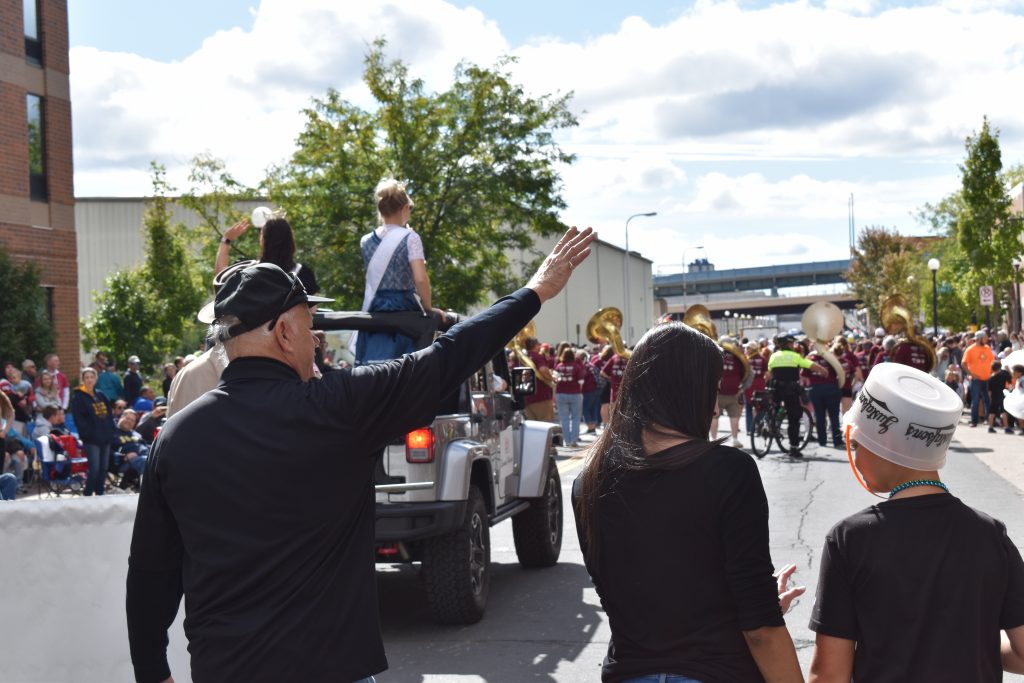 Man waves to parade crowd.